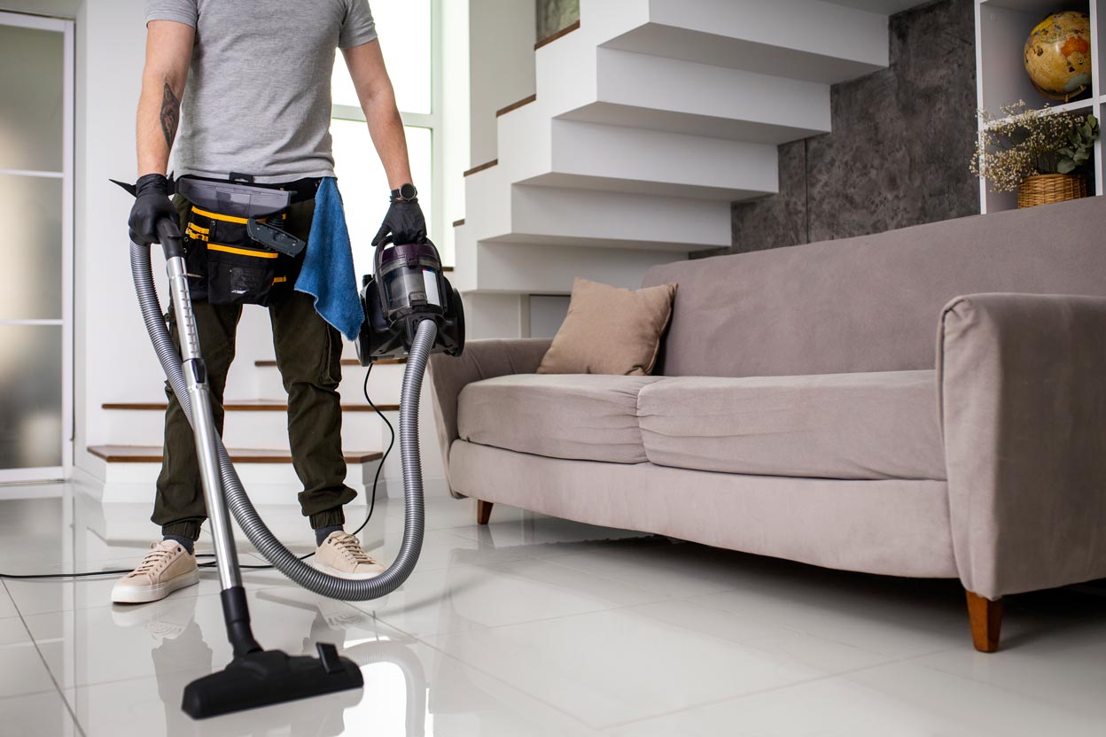 Professional property handover cleaning in Dubai by Churchill Gulf. A specialized cleaner prepares a modern apartment for new tenants, ensuring the living area meets RERA and Dubai real estate standards for move-in readiness.